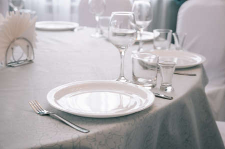 Empty white dinner plate on a table in a restaurantの写真素材