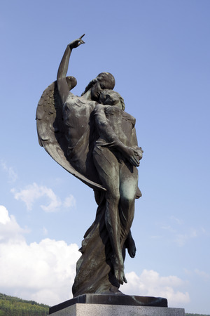 SPISSKE PODHRADIE, SLOVAKIA - AUGUST 10, 2014: The angel takes the soul to heaven. The bronze sculpture by Alexej (Elek) Lux (1883-1941) on the grave monument of Jan Harmatta and his wife.のeditorial素材