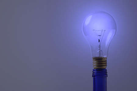 Blue light bulb on blue bottleの写真素材