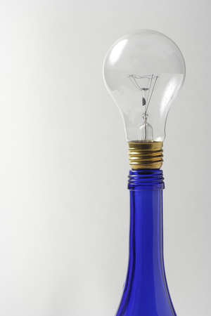 Clear light bulb on blue oil bottleの写真素材