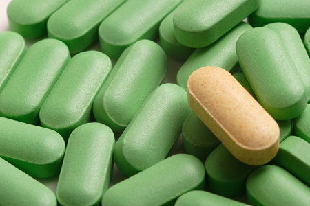 One yellow caplet amongst greenの写真素材