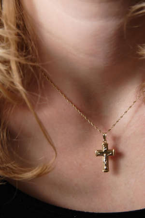 A cross pendant necklace hanging from a sexy young lady's neck.の写真素材