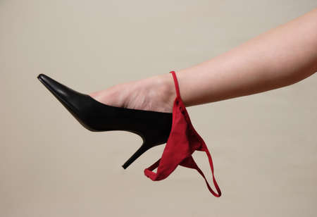 Valentine Red thongs hanging from lady's sexy legの写真素材