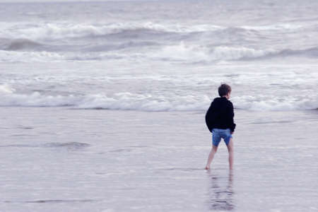 Boy walking in the seaの写真素材