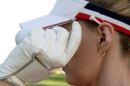 Lady golfer with a white tee behind her earの写真素材