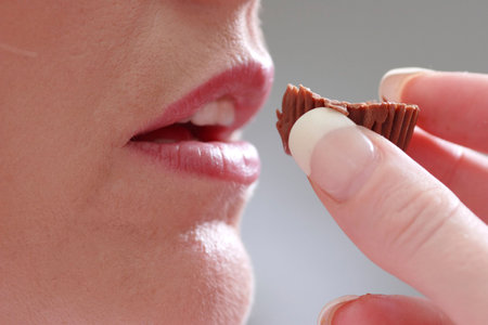 close up of woman about to eat a chocolateの写真素材