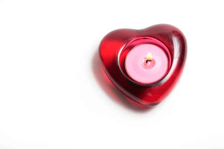 Red heart candle with flame isolated on whiteの写真素材