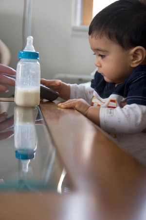  standing beside glass covered coffee table with reflection of bottle in glassの写真素材