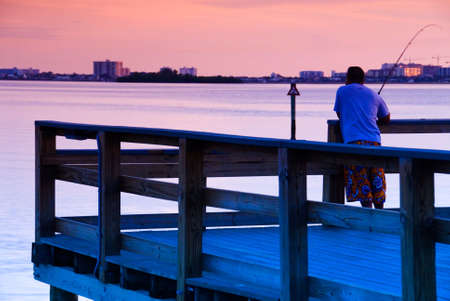 Man fishing off a pier in Florida at sunsetの写真素材