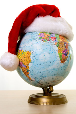 Round globe with a red santa hat showing concept of Christmas around the worldの写真素材