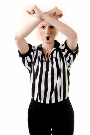 Attractive blonde woman wearing black and white striped referee uniform blowing on a whistle making a hand signalの写真素材