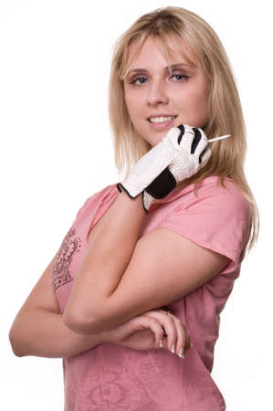 Attractive blond woman wearing golf glove holding a tee in hand over whiteの写真素材