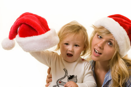 Adorable caucasian blond  girl toddler sitting with mom with Santa caps over white