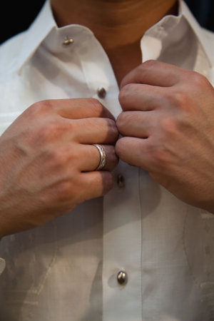 Wedding Groom buttoning shirt