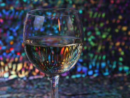 A glass of wine on a multi-color backgroundの写真素材