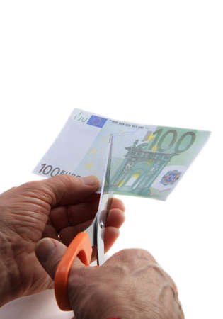 Hands with scissors as symbol of cutting the spending billの写真素材
