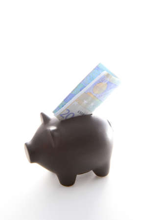A black piggybank with money on a white backgroundの写真素材