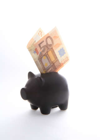 A black piggybank with money on a white backgroundの写真素材