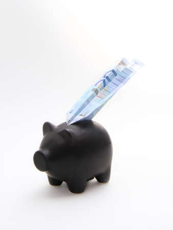 A black piggybank with an airplane of money on a white backgroundの写真素材
