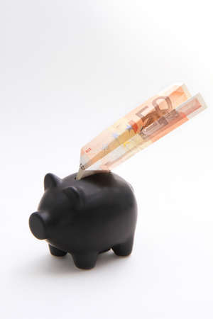 A black piggybank with an airplane of money on a white backgroundの写真素材