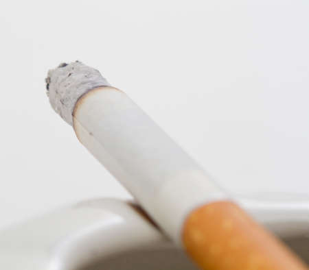A blurry lit cigarette on a white backgroundの写真素材