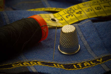 Italian fabric with a needle, a fuze, and a blurred rulerの写真素材