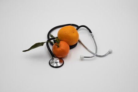 Orange and stethoscope on a white bacgroundの写真素材
