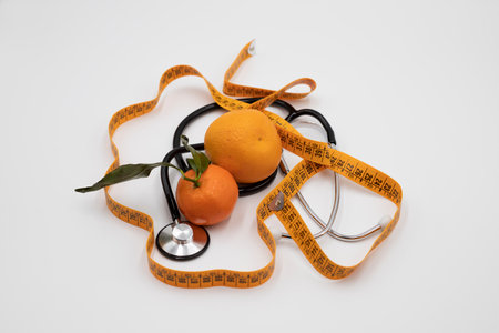 Orange stethoscope and a centimeter on white backgroundの写真素材