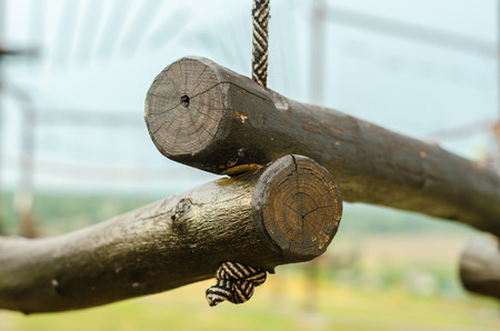 small wooden logs of a suspended rope road close-up against a blue skyの写真素材