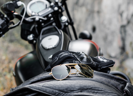sunglasses and gloves on the background of a motorcycle fuel tankの写真素材