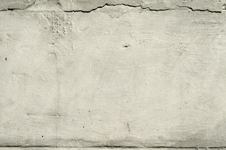 white texture old concrete wall with remains of plaster with cracksの写真素材
