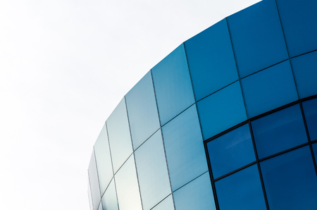 facade of an office building with blue walls and mirrored windowsの写真素材