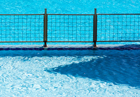 metal fence grill in the pool with blue water