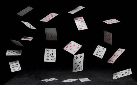 playing cards fall on a black tableの写真素材