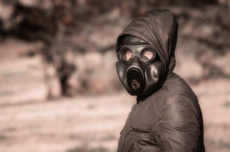 portrait of a man in a gas mask and a hood closeup