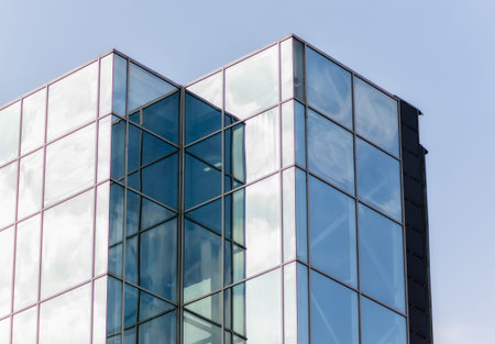 windows of a tall office building of a skyscraper without people with reflection of sky
