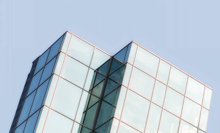 windows of a tall office building of a skyscraper without people with reflection of cloudsの写真素材