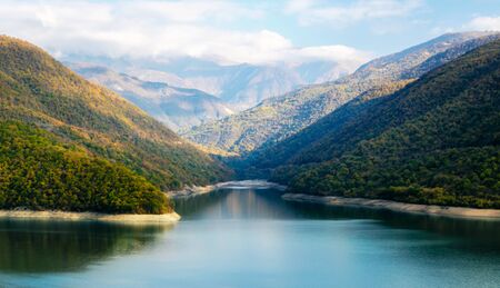 autumn mountain landscape with green forest and lake and sky and clouds in Georgiaの写真素材