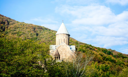 old antique christian church with a dome and a cross on a mountain in a forest in Tbilisi Georgia...