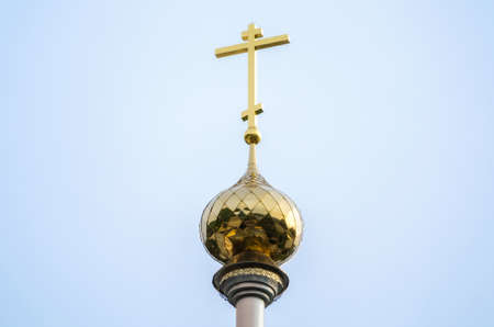 christian church with a dome and a cross without people against a blue skyの写真素材