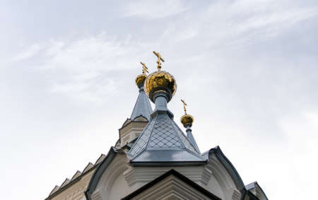 bottom view domes of christian church with crosses on blue sky background in Ukraineの写真素材