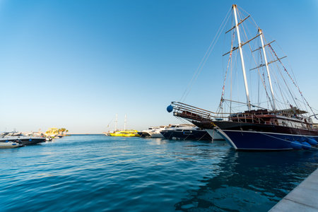 empty pier without people with a sailboat with modern ships and boats in the Red Sea Egypt Hurghada