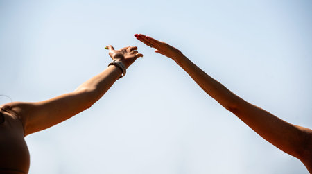 hands of people doing yoga on the beach close up