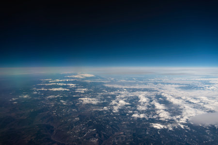 panorama view from the airplane window to mountains clouds and blue sky