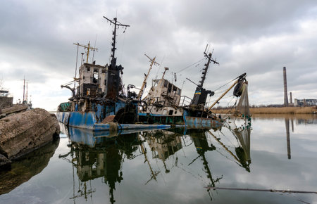 abandoned old damaged ships in the port without people during the war between Ukraine and Russiaの写真素材