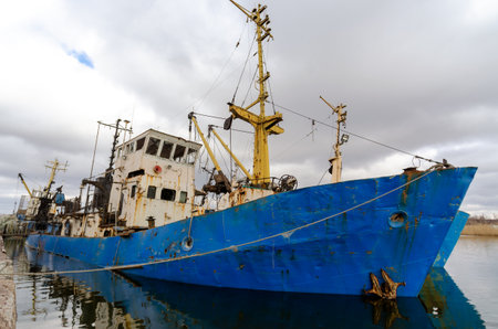 abandoned old damaged ships in the port without people during the war between Ukraine and Russiaの写真素材