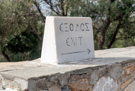 stone with the inscription "exit" in Greek and English close upの写真素材