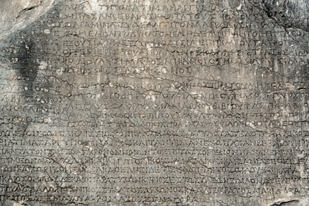ancient greek letters in stone abstract background close upの写真素材