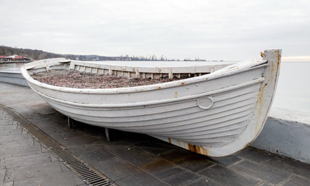 old rusty wooden white boat on a concrete pier at sunset close upの写真素材