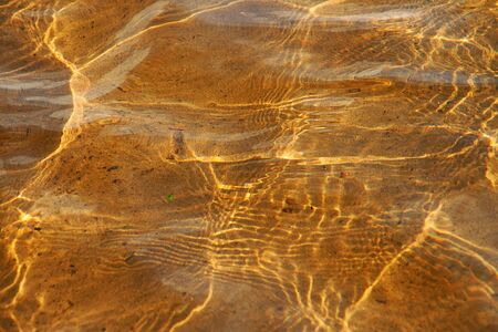 clear yellow water with sun glareの写真素材